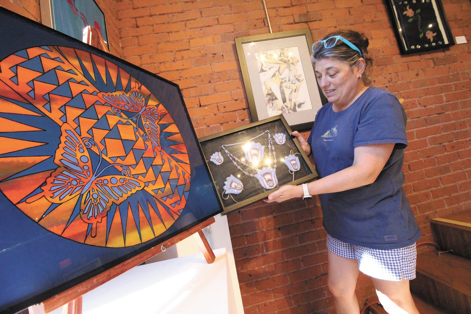 HER FAVORITE: Danielle Salisbury, executive director,  holds a work by Hebe-Tee-Tse-Lee in the Side by Side show bringing together a diverse group of artists now on display at the Warwick Center for the Arts through Aug. 20.